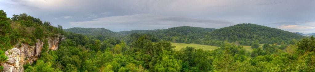 A panoramic view from atop Arkansas bluffs overlooking beautiful hilly green fields and woodlands